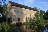 Western elevation of Grade II-listed early-19C Warmington Mill with one of the mill races passing underneath.
